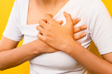 Asian woman clutching her chest, chest pain, acute pain, heart attack, heart disease symptoms. concept of health and heart disease treatment