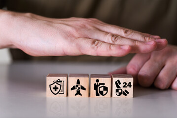 Insurance signs on wooden cubes, hands covering wooden cubes.