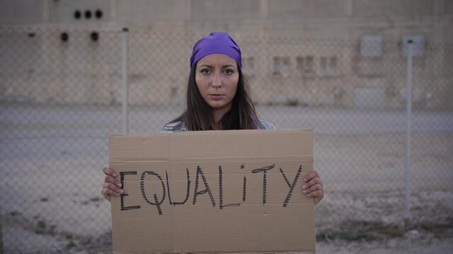 Feminist woman holding a placard saying Equality. Demonstration banners.