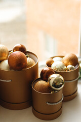 Close up of decorative Christmas brown balls in the gold box on a window