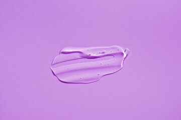 Cosmetic smear. Appearance of the texture of the transparent gel on purple background. Natural skincare products. Beauty concept for face and body care