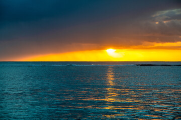 Amazing sunset above the ocean. Yellow, blue and orange colors.