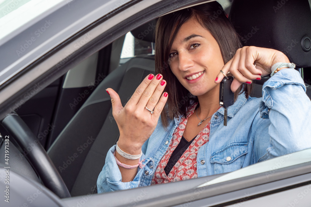 Wall mural pretty young brunette driving car