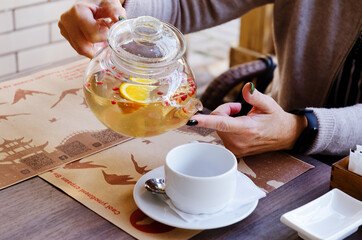 Top view of glass teapot and cups of tea on a table at restaurant close up. Tea ceremony. Holiday concept. Hot winter drinks. 