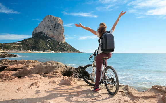 happy woman on the bike enjoy beautiful view on rock and sea