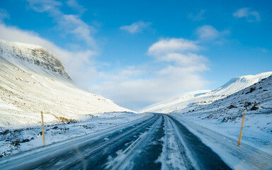 On a road trip to South Iceland on a bright sunny day in winter when the ground and the mountains are covered by snow.