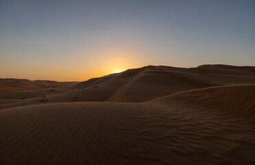 Fototapeta na wymiar Sunset in the arabian desert with rolling sand dunes in Abu Dhabi, United Arab Emirates