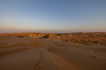 Obraz na płótnie Canvas Sunset in the arabian desert with rolling sand dunes in Abu Dhabi, United Arab Emirates