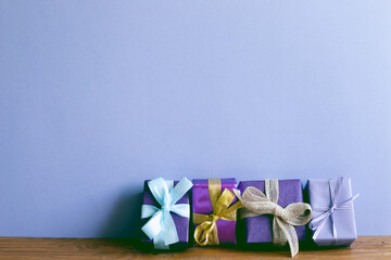 Gift boxes on wooden table. purple wall background. christmas birthday new year concept