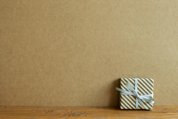 Gift box on wooden table. brown wall background. christmas birthday new year concept
