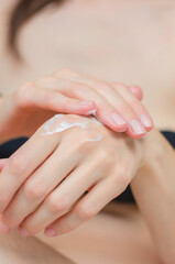 Obraz na płótnie Canvas Moisturizer on female hands close-up. A woman applies moisturizer to her hands. Skin care