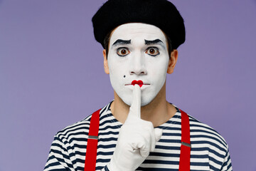 Close up secret vivid young mime man with white face mask wears striped shirt beret say hush be...
