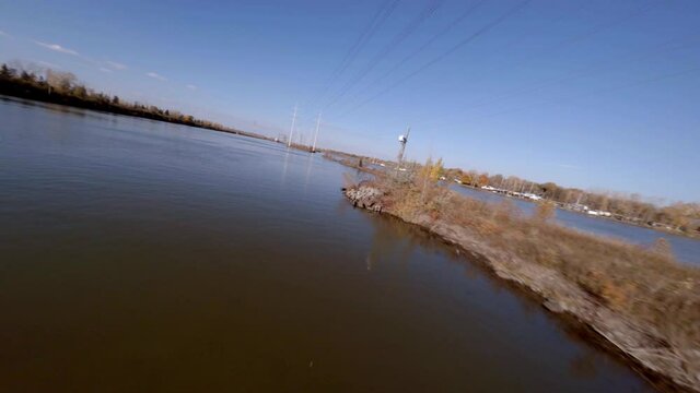 FPV Acrobatic Flying Manoeuvres Over Saint Lawrence River Towards White Towers Carrying Cables