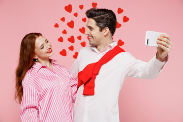 Young couple two friends woman man 20s in casual shirt doing selfie shot on mobile cell phone hug cuddle isolated on plain pastel pink background studio Valentine's Day birthday holiday party concept