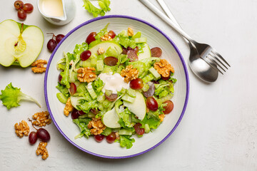 Waldorf salad, made of green apples, celery, walnuts, grapes, dressed in mayonnaise, and served...