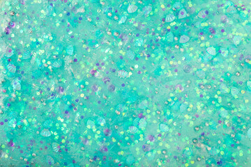 Green, turquoise glitter slime background. sticky flexible substance. abstract texture. closeup
