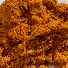 Detailed and large close up shot of powdered curcuma spice.