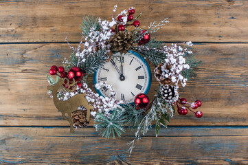 Vintage Christmas clock with frame of Christmas wreath on a black background. Copy space, place for text with Christmas clock concept