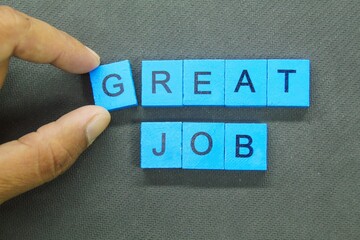 hand holding a blue square with the word great job
