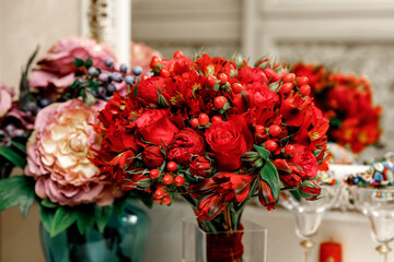 Wedding flowers, red color, bridal bouquet close-up. Decoration made of roses, hypericum and decorative plants, pink peonies close-up, selective focus, nobody