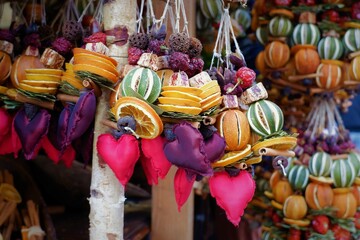 dried fragrant winter fruit ornaments with red textile hearts at a vendor on the Christmas market...