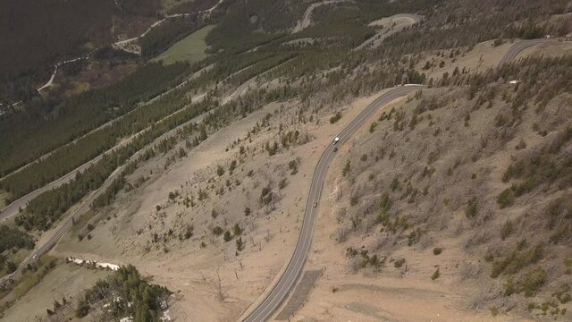 Mountain road switchbacks with cars from the air