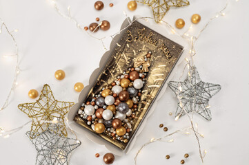 Christmas chocolate card with a Christmas tree made of sweet balls, on a white background with stars and a garland, the inscription in Ukrainian, Happy New Year greetings