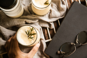 Corn juice smoothie on a white sieve on the side with glasses, book prop Place on wood table. Top view