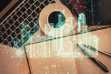 City drawing over computer on the desktop background. Top view. Double exposure. Smart home concept.