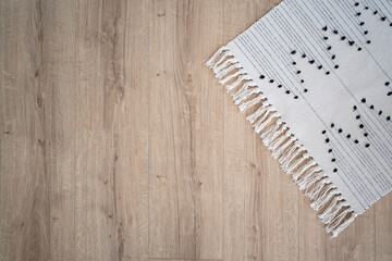 Laminate parquete floor. Light wooden texture. White carpet.