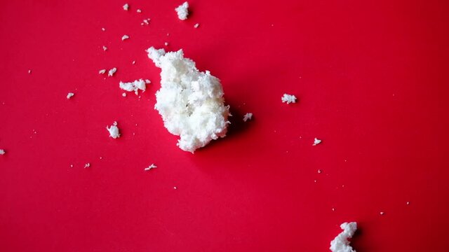 snowball falls and breaks on red background with copy space. christmas and new year 2022 concept