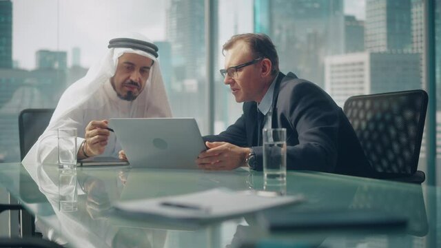 International Business Consultant Advices on Diversification of Investment Portfolio to Successful Arab Company Owner. Multicultural Meeting in Modern Office Between American and Emirati Businessman.