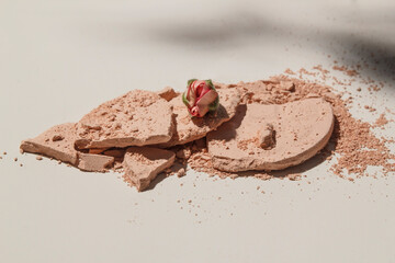 Face powder. Broken pieces of cosmetic powder with hard shadow . Cosmetic smear.