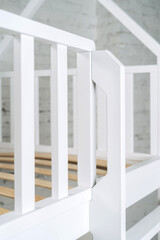 The image of the grates child's bed against the backdrop of the white wall.