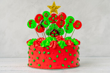 Christmas cake with balls with an inscription in German Frohes Fest Happy holiday. Decoration for the holiday. White background.