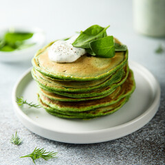 Traditional homemade spinach pancakes with sour cream