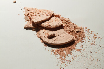 Face powder. Broken pieces of cosmetic powder with hard shadow . Cosmetic smear.