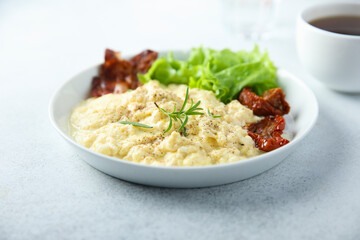 Homemade scrambled eggs with fried bacon