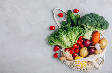 Mesh bag with vegetables. Organic Broccoli, celery, ginger, cucumbers, lettuce and potato in cotton shopper bag