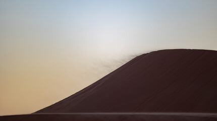Naklejka na ściany i meble Sunset in the arabian desert with rolling sand dunes in Abu Dhabi, United Arab Emirates