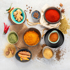 Assortment of Indian spices on gray background.