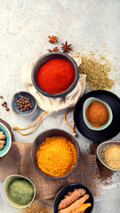 Assortment of Indian spices on gray background.
