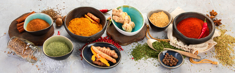 Assortment of Indian spices on gray background.