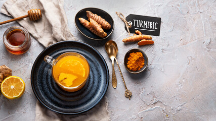 Healthy turmeric golden tea on light gray background.
