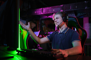 Professional young caucasian gamer playing online on his PC. He upset because of losing the game © nazarovsergey
