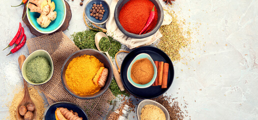 Assortment of Indian spices on gray background.