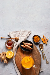 Healthy turmeric golden tea on light gray background.