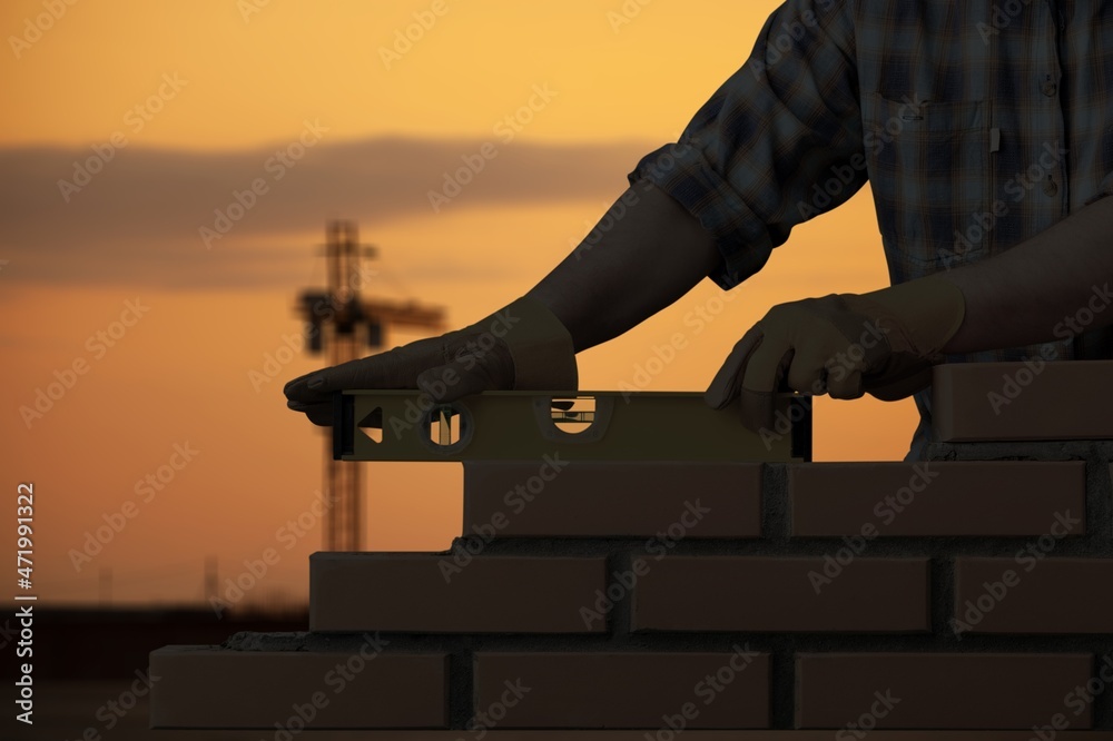 Wall mural silhouette construction mason worker bricklayer, construction laying bricks