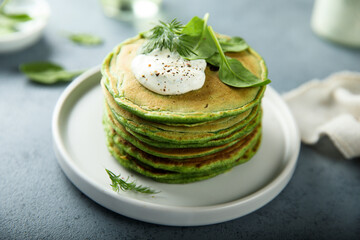 Traditional homemade spinach pancakes with sour cream