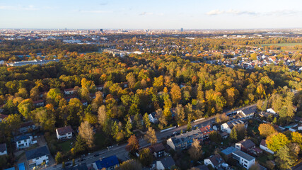 Naklejka premium Munich suburbs and forest seen from drone view in fall season